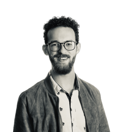 Portrait of Dalton Touchberry smiling, wearing glasses and a jacket.